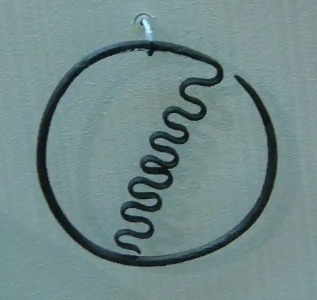 A wavy snake-like symbol inside a circle made of metal